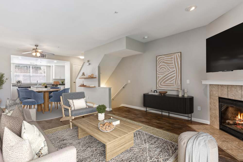 Townhome living room with fireplace, dining area, and kitchen with white cabinets and stainless steel appliances at Azure Apartment Homes in Petaluma, California