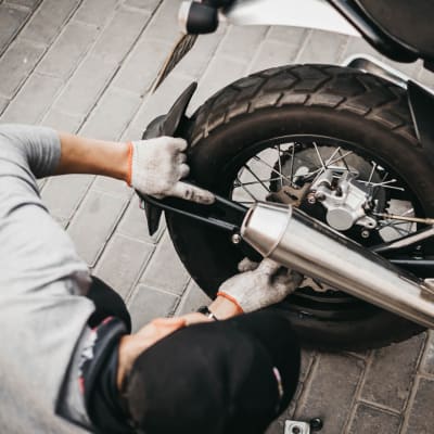 A resident working on a motorcycle in a garage at Seal Beach Officer Housing in Seal Beach, California