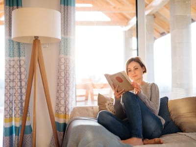 Woman reads a book in her new apartment at Laguna Ellis in Concord, California