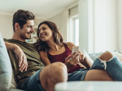 Couple sitting on their couch at City Walk Apartments in Concord, California