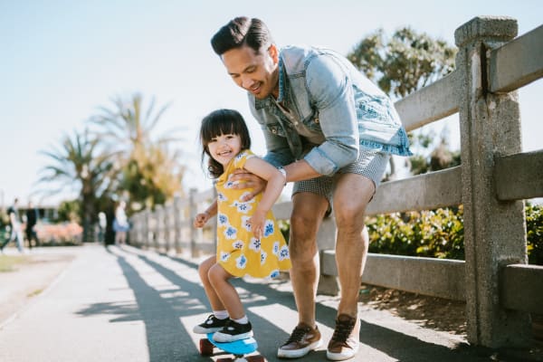 A father helping his daughter skateboard near Ravella at Town Center in Jacksonville, Florida