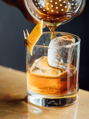 An old fashioned strained over large ice cubes at a cocktail lounge near Jefferson SoLA in Los Angeles, California