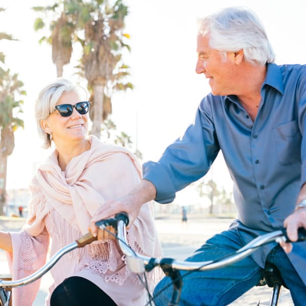 Two residents riding bikes together at Pacifica Senior Living Santa Barbara in Santa Barbara, California