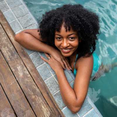 Resident posing for a photo inside the swimming pool at Centro at Davie Apartments, Davie, Florida
