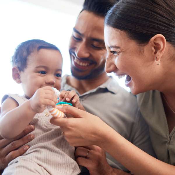 A family smiles in their apartment at Attain at Quarterpath, Williamsburg, Virginia