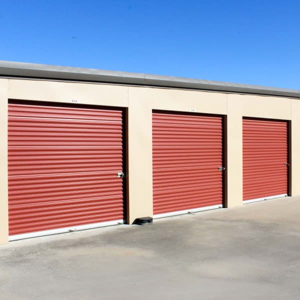 Outdoor storage units with red doors at StorQuest Self Storage in Kyle, Texas
