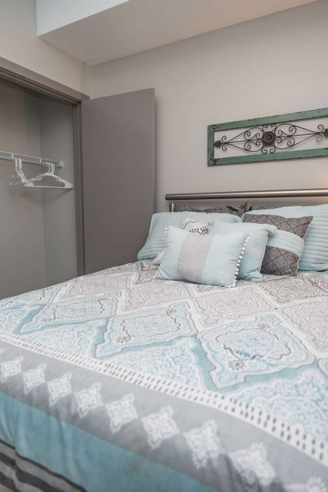 Comfortably furnished primary bedroom in a model apartment at Diamond Place II in Grand Rapids, Michigan