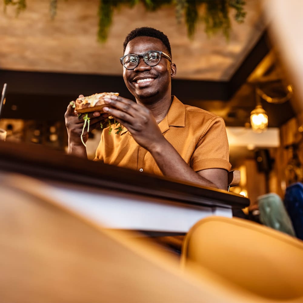 Resident enjoying a burger at a restaurant near our Oak Tree community at Mission Rock at Sonoma in Sonoma, California