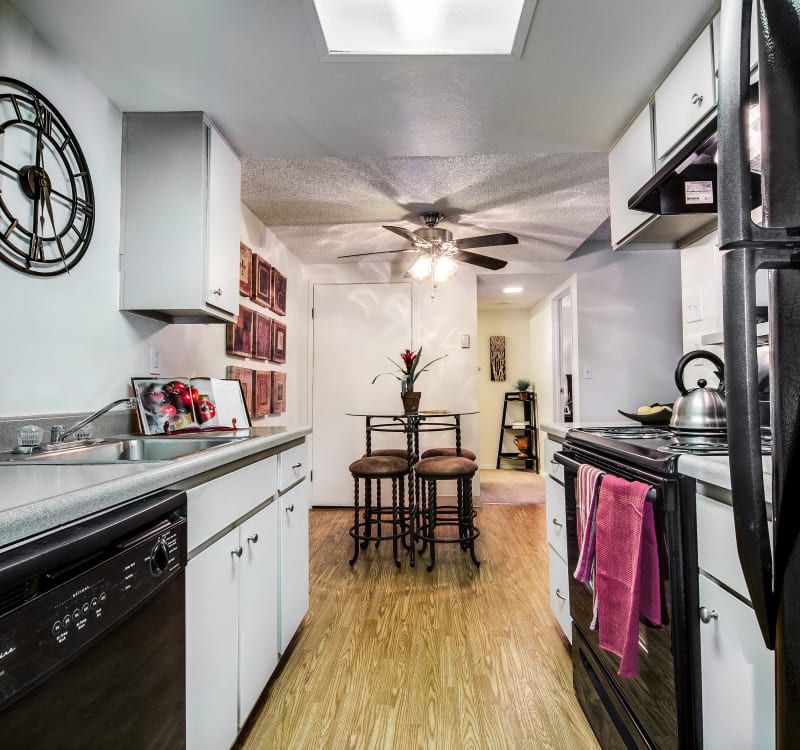 Kitchen with sleek black appliances and granite-style countertops in a model home at Santana Ridge in Denver, Colorado