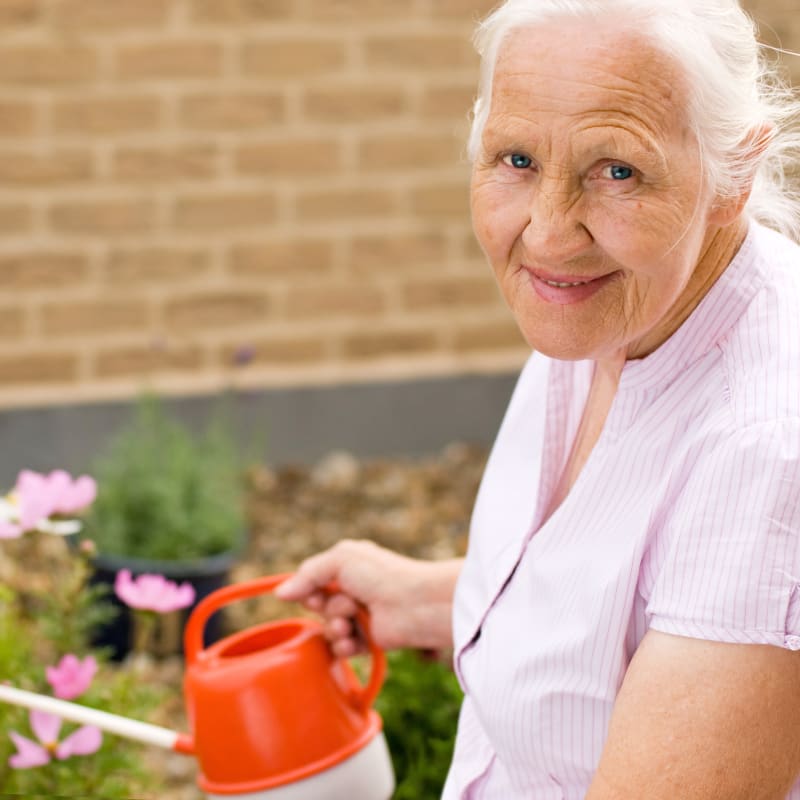 Resident watering plants outside at The Hearth at Southbury in Southbury, Connecticut