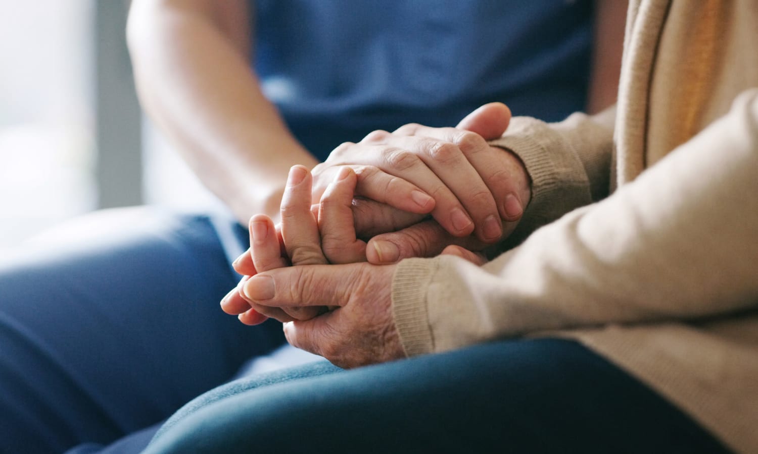 Resident holding hands with a caretaker at Traditions of Hershey in Palmyra, Pennsylvania