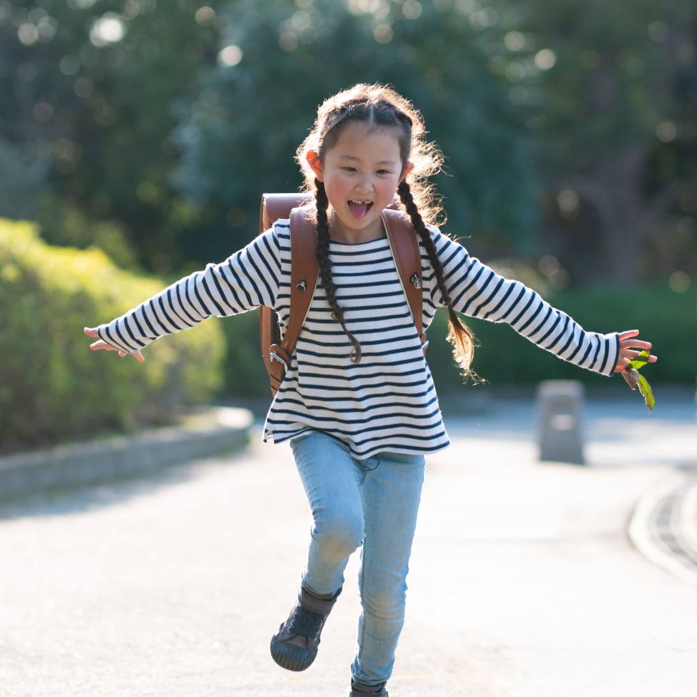 Young resident walking home from school to Park at Northside Apartments & Townhomes in Macon, Georgia