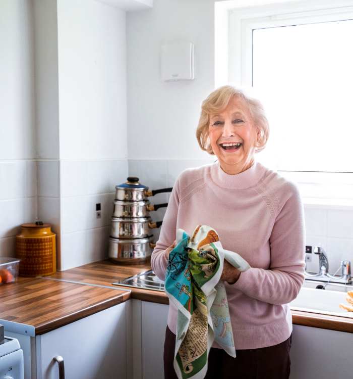 Woman smiling in her kitchen at The Heights in La Puente, California