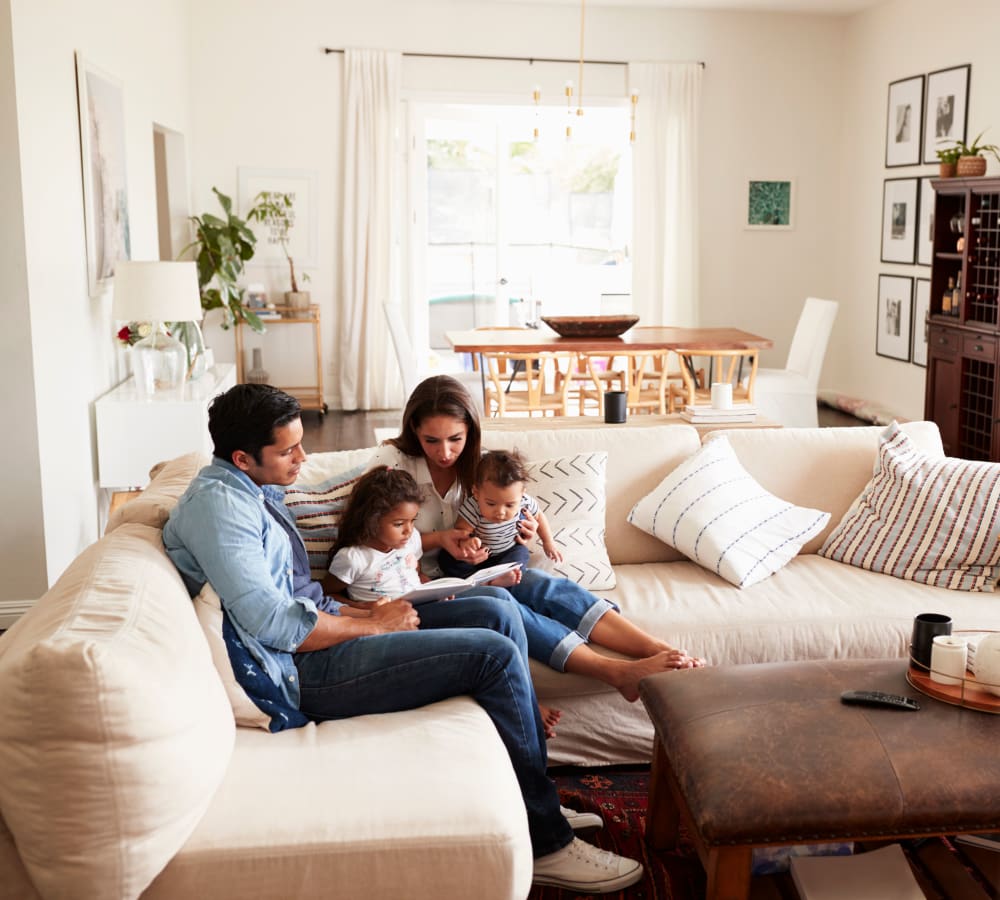 A mother and father sitting on a couch with their children at The Gables in Ridgeland, Mississippi