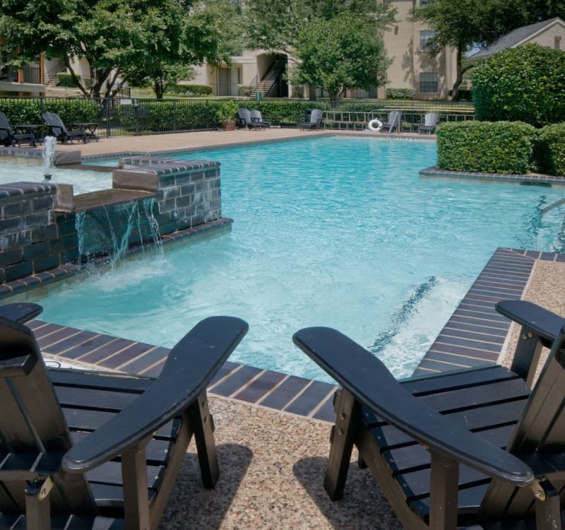 Chaise lounge chairs and a fountain near the pool at Rockbrook Creek in Lewisville, Texas