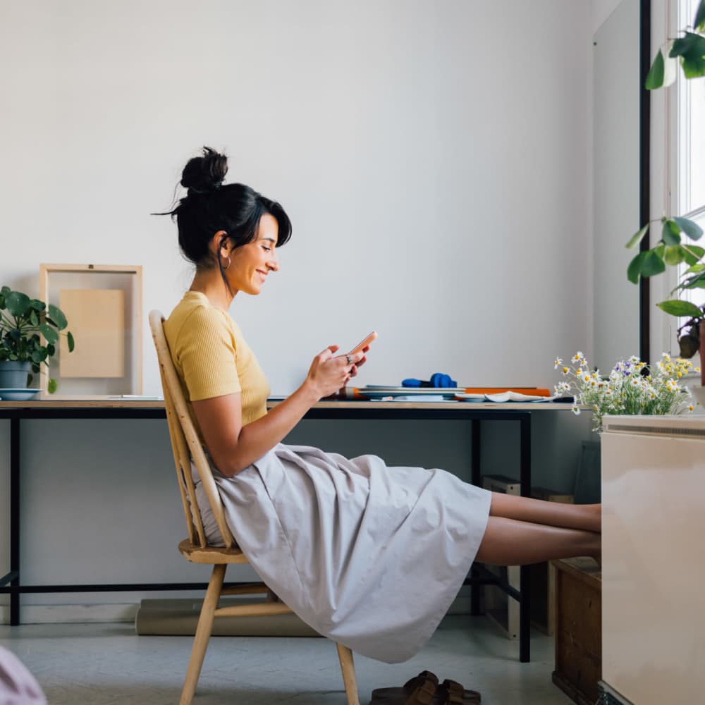 Woman sitting in a bright room using smartphone at Alton Park in Fort Worth, Texas