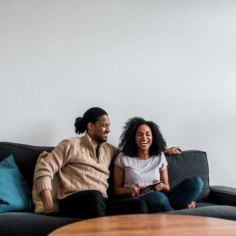 Resident couple having a good time in their apartment living room at The Indigo Apartments in Franklin, North Carolina