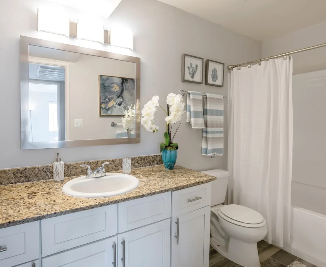 Bathroom with an oversized vanity with granite countertops at Onnix in Tempe, Arizona