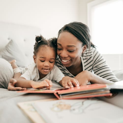 A mother reading a story with her daughter at Beech St. Knolls in San Diego, California