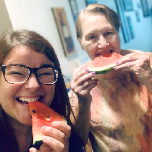 Residents and team member eating watermelon at Oxford Villa Active Senior Apartments in Wichita, Kansas