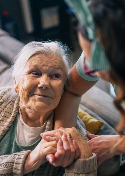 Staff member holding a resident's hands at Grand Villa of Ocala in Ocala, Florida