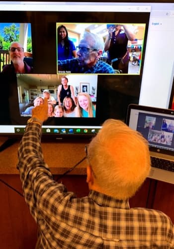A resident virtually visiting friends at Amber Grove Place in Chico, California. 