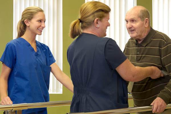 Nurse assisting resident with walking at O'Fallon in O'Fallon, MO