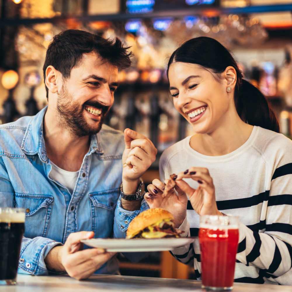 Resident couple sharing a laugh over a meal at their favorite restaurant near The Trail Lakes in Fort Worth, Texas