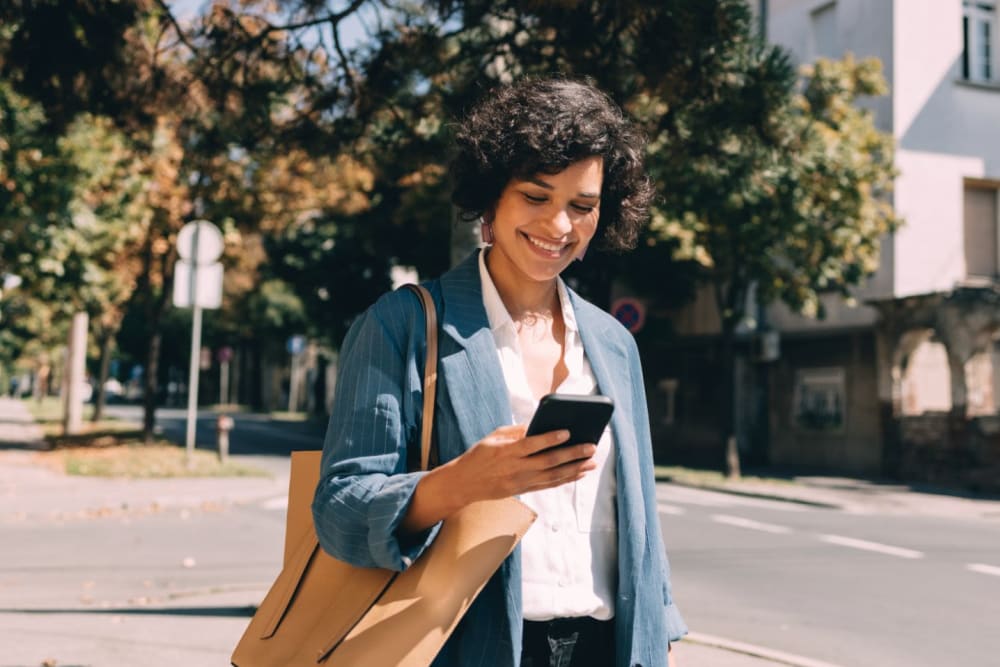 Resident looking at her phone while walking home from work near Lotus Village in Austin, Texas