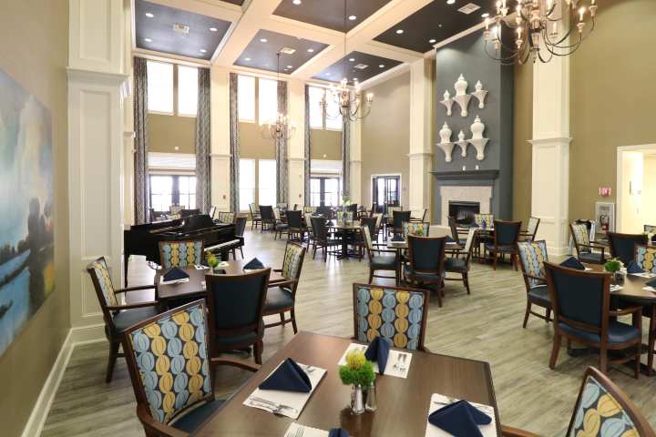 Experience elevated dining at The Landing at Watermere Frisco. This grand dining room features elegant chandeliers, high ceilings, and a warm, inviting atmosphere where residents enjoy chef-prepared meals in a sophisticated setting designed for comfort and community.