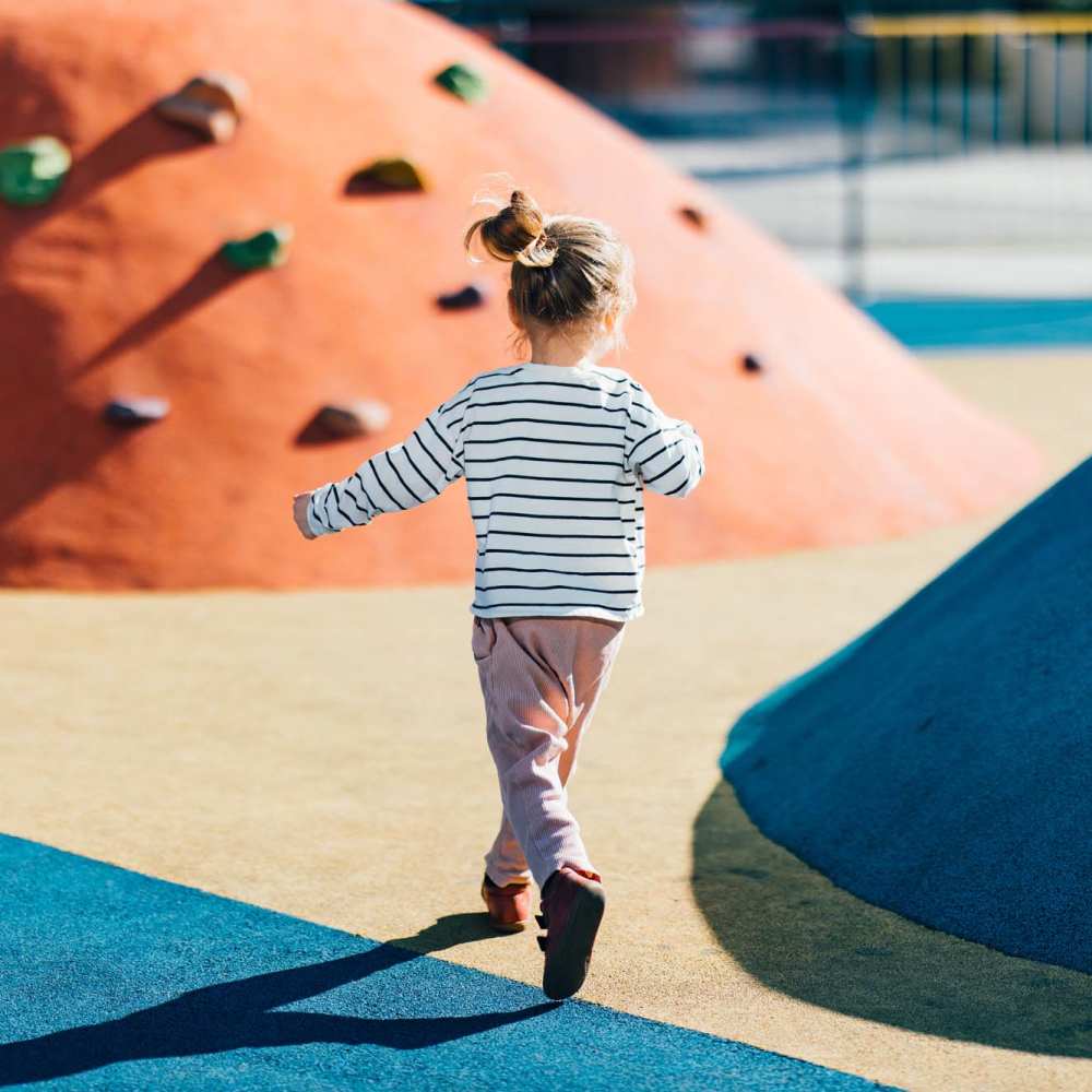 Child playing at colorful playground at Alton Park in Fort Worth, Texas