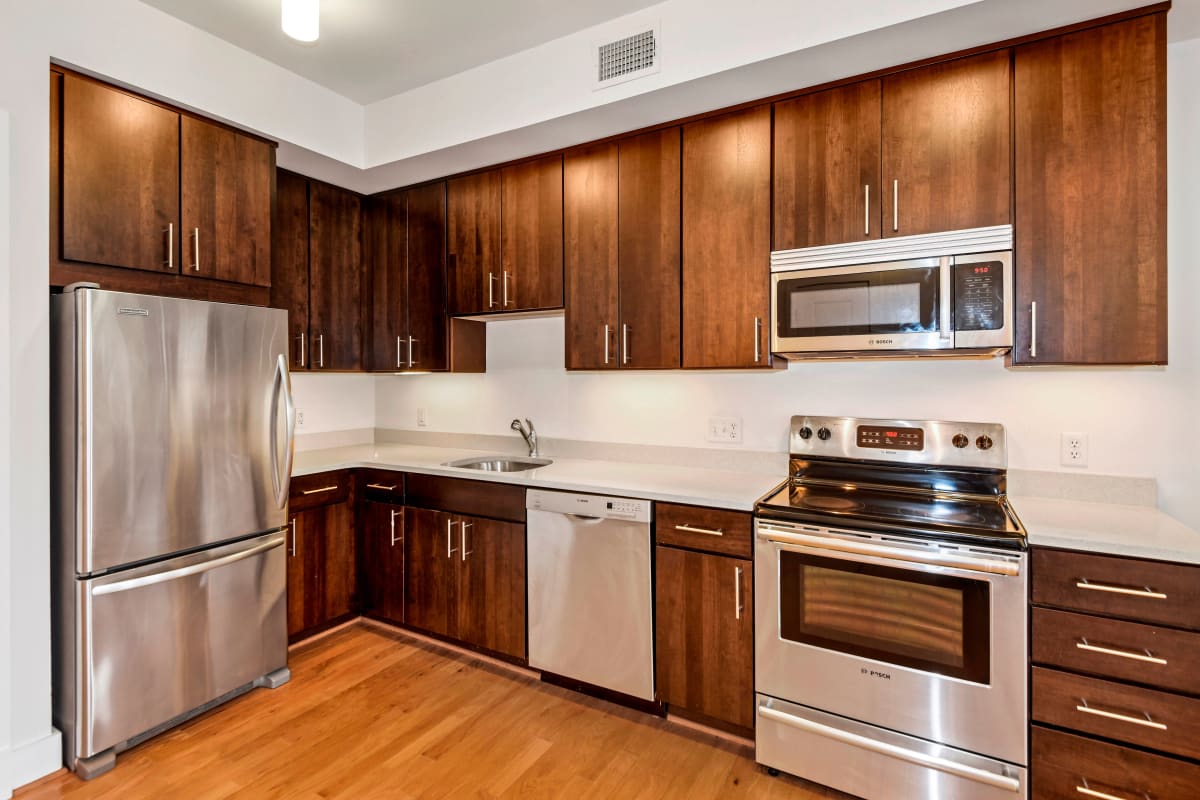 Sleek kitchen with dark wood cabinets and stainless steel appliances at Griffin Apartments in Washington, District of Columbia