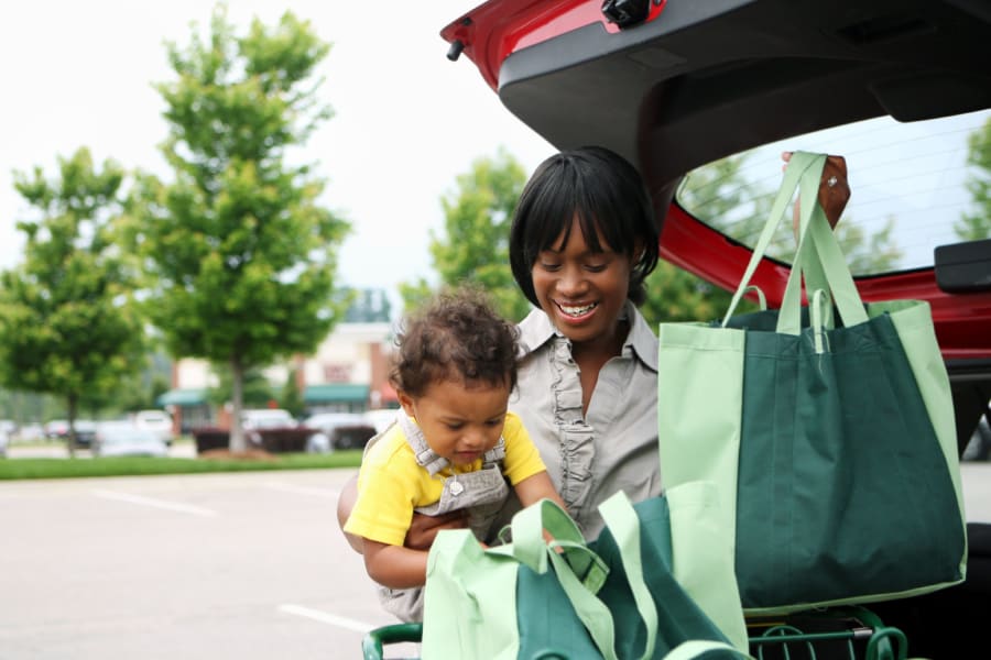 A mother and child loading groceries into a car near Prairie Reserve in Cedar Rapids, Iowa