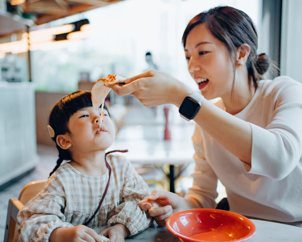 A mother feeding her daughter at Pacific View in Oceanside, California