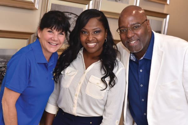 Three people smiling at camera