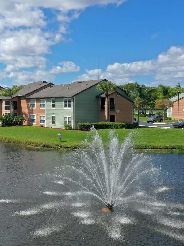 Exterior view of the property with lake view at Visions at Willow Pond apartments in West Palm Beach, Florida