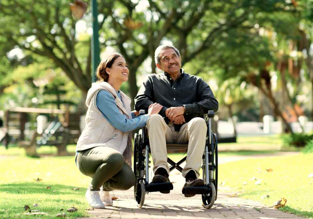 Resident in a wheelchair at a park with another resident near Seapointe Villas in Costa Mesa, California 