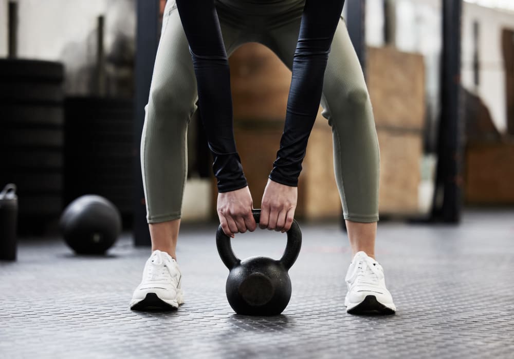 Resident exercising with a kettlebell in the fitness center at Mosaic in Los Angeles, California