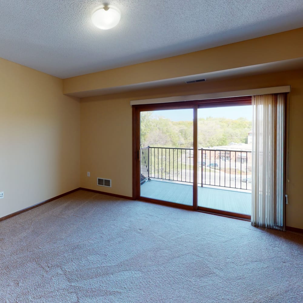 Well-furnished primary bedroom with large bay windows in a model home at Oaks Glen Lake in Minnetonka, Minnesota