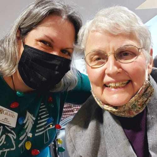 An excited masked caretaker at The Oxford Grand Assisted Living & Memory Care in Wichita, Kansas