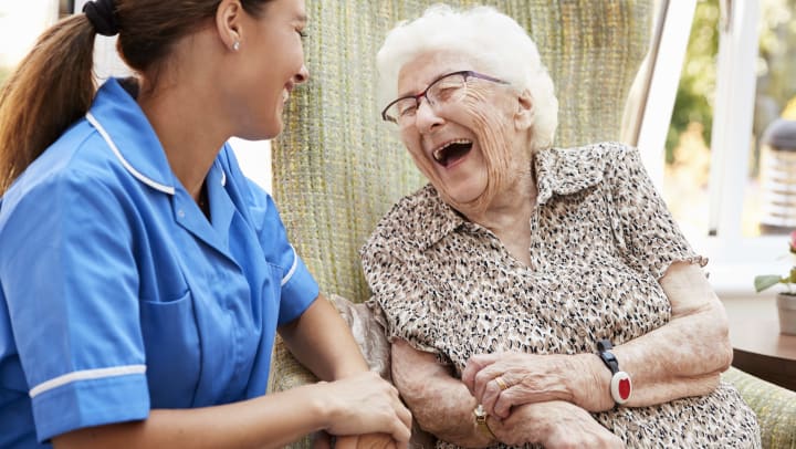 Nurse and patient laughing while having a conversation.