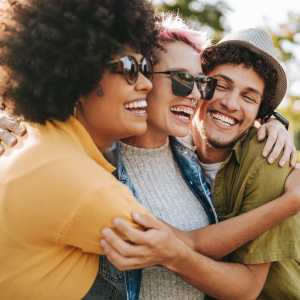 Three smiling residents hugging one another at Artisan Living Mills River in Mills River, North Carolina