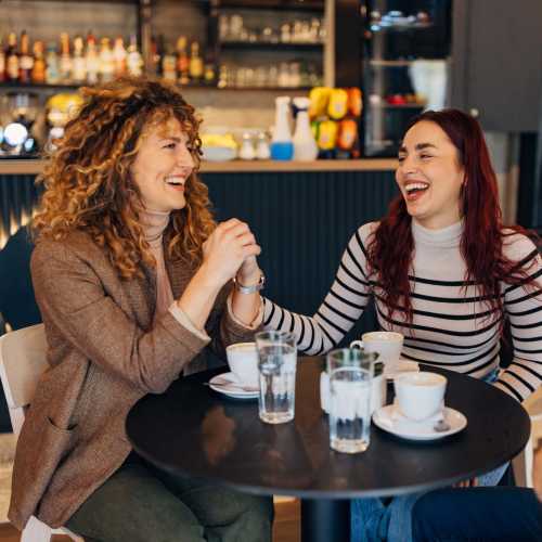 Happy friends having coffee at a cafe near The Marke Apartment Homes in Santa Ana, California