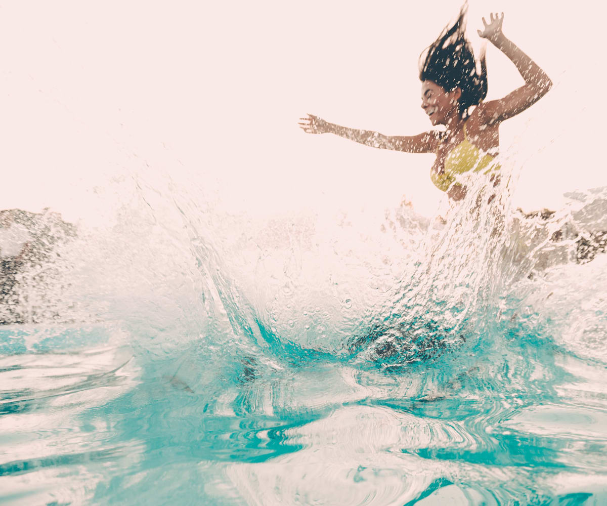Woman jumping into the pool at Stonehorse Crossing Apartments in Oklahoma City, Oklahoma