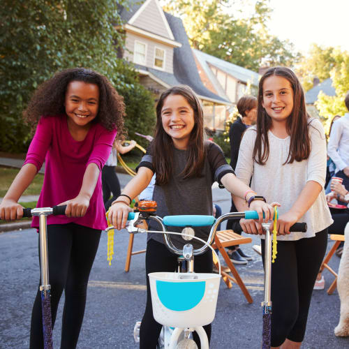 Children riding on a bicycle and scooters near a residence at Bayview Hills in San Diego, California