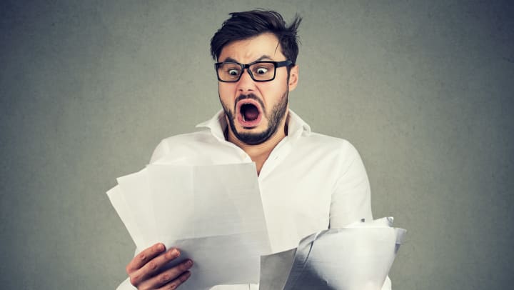Man looking at papers with a surprised look on his face.