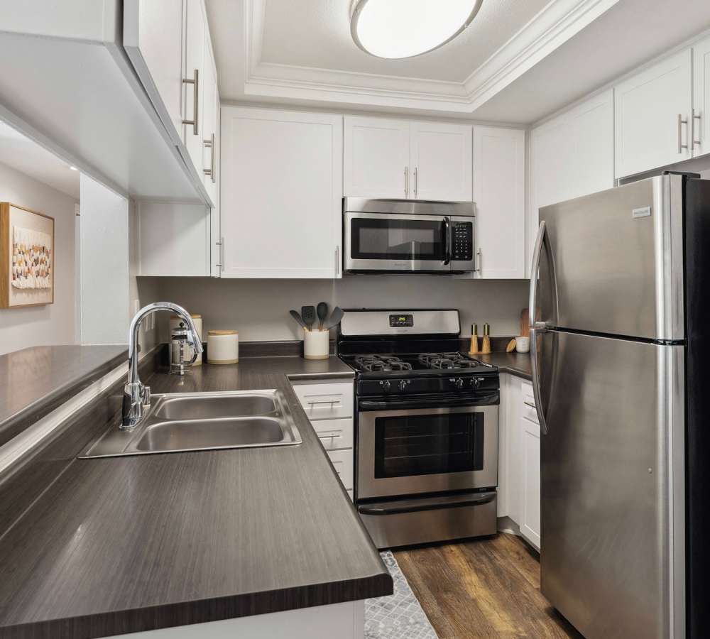 Kitchen with white counters, grey countertops and stainless steel appliances at Shadow Ridge Apartment Homes in Simi Valley, California