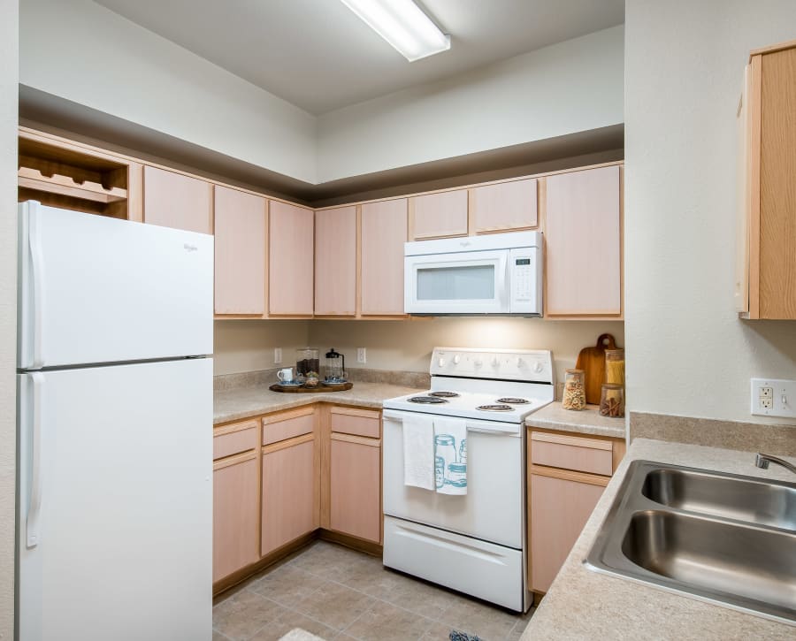 Large kitchen with a dual-basin sink and plenty of storage space in a model home at Rockbrook Creek in Lewisville, Texas