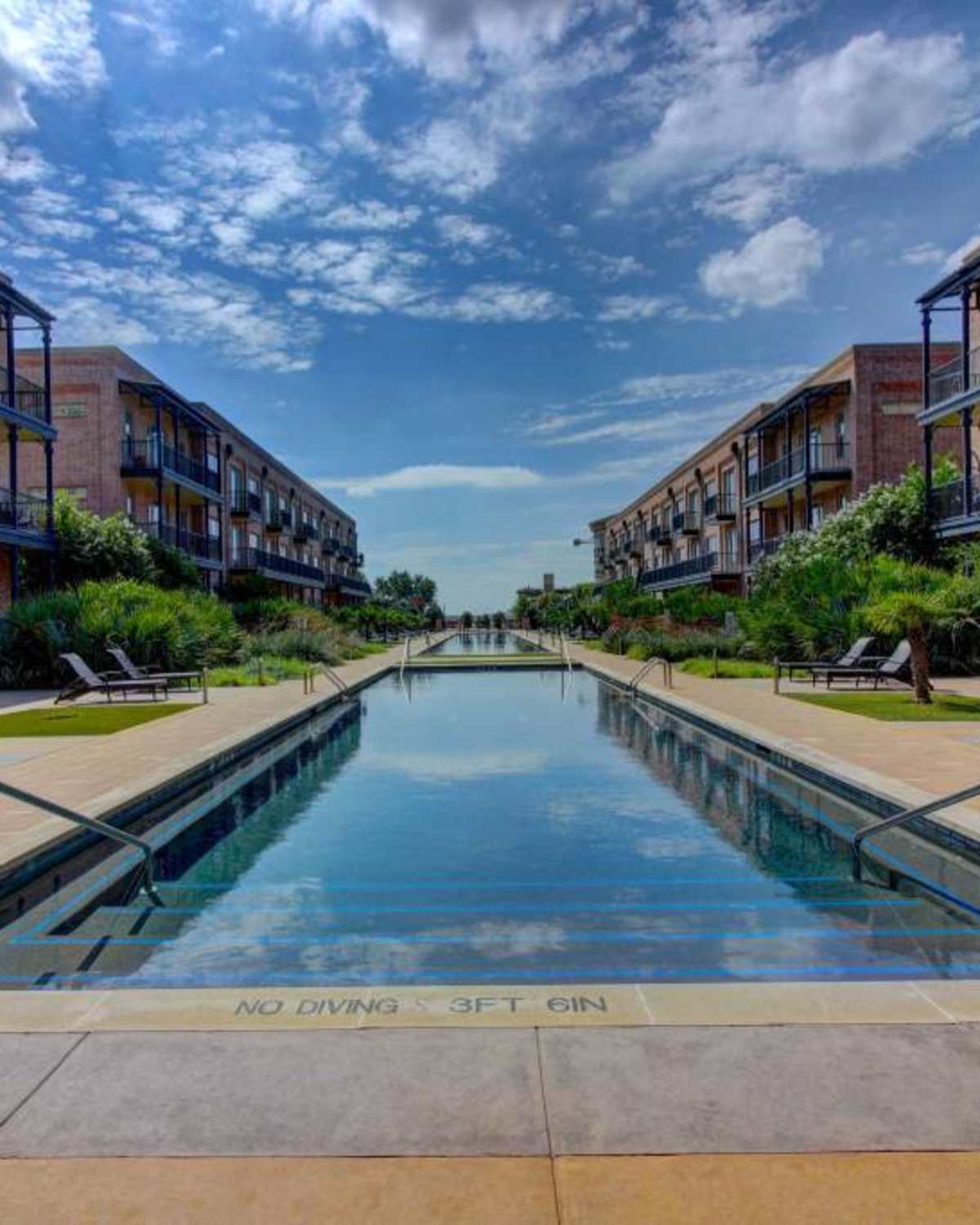 Resort-style pool with lounge chairs at Flatiron District at Austin Ranch, The Colony, Texas