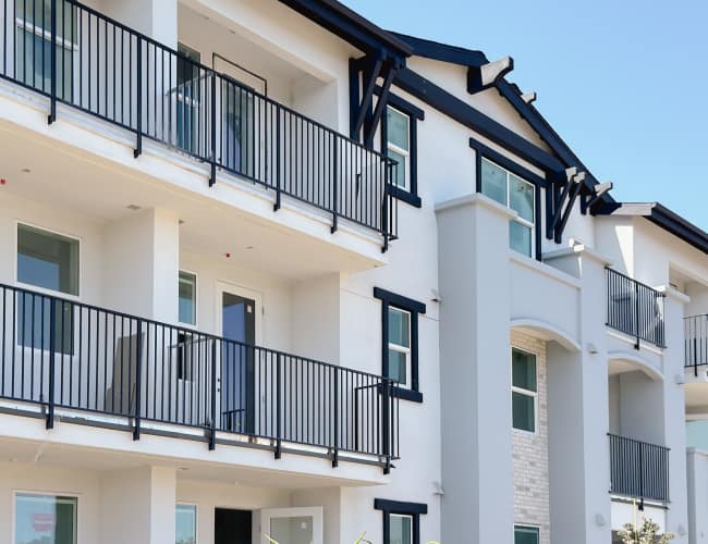 Exterior view of the community building with balcony view at The Palms at RIVA in Solana Beach, California